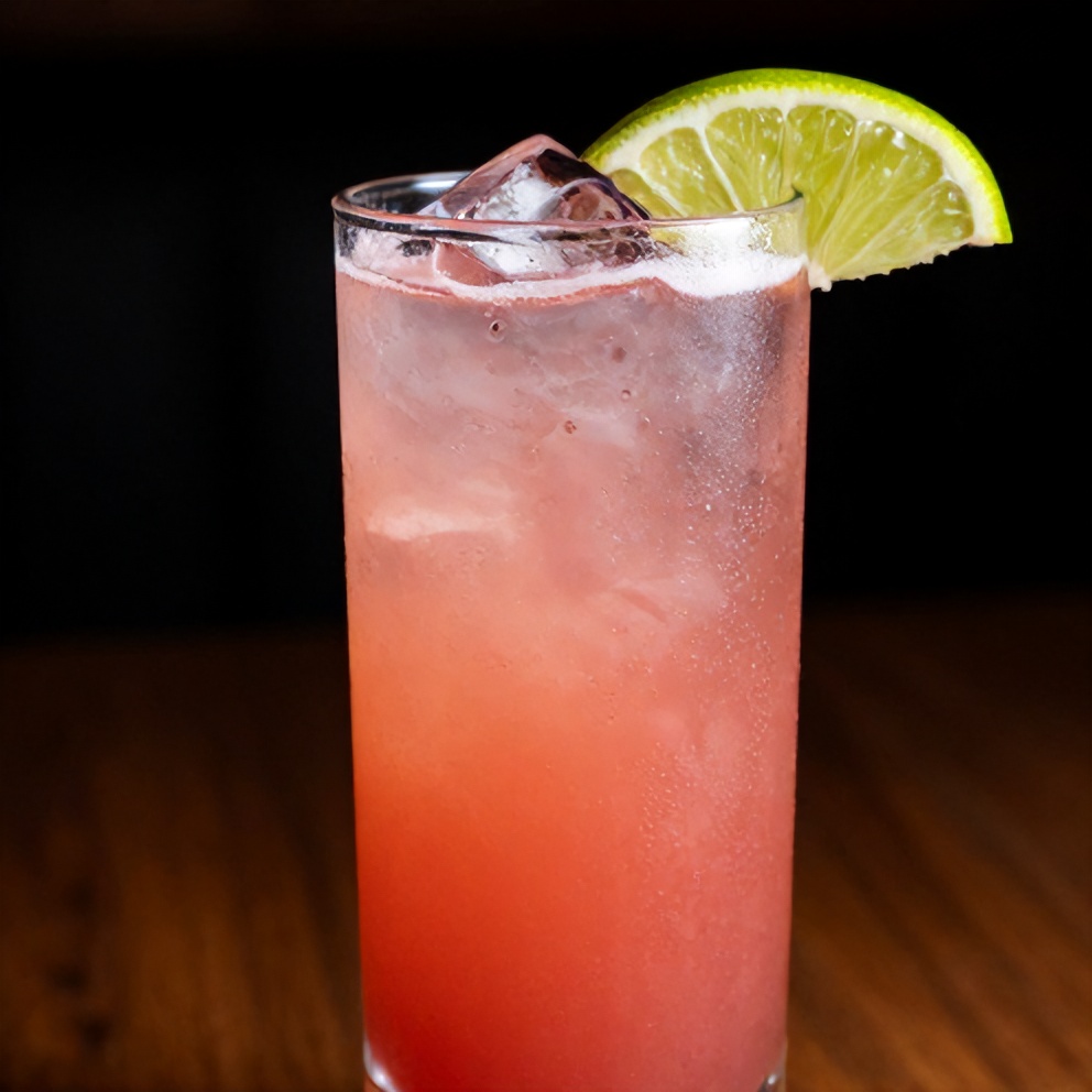 Raspberry Passionfruit Tequila Sour Cocktail garnished with a lime wheel
